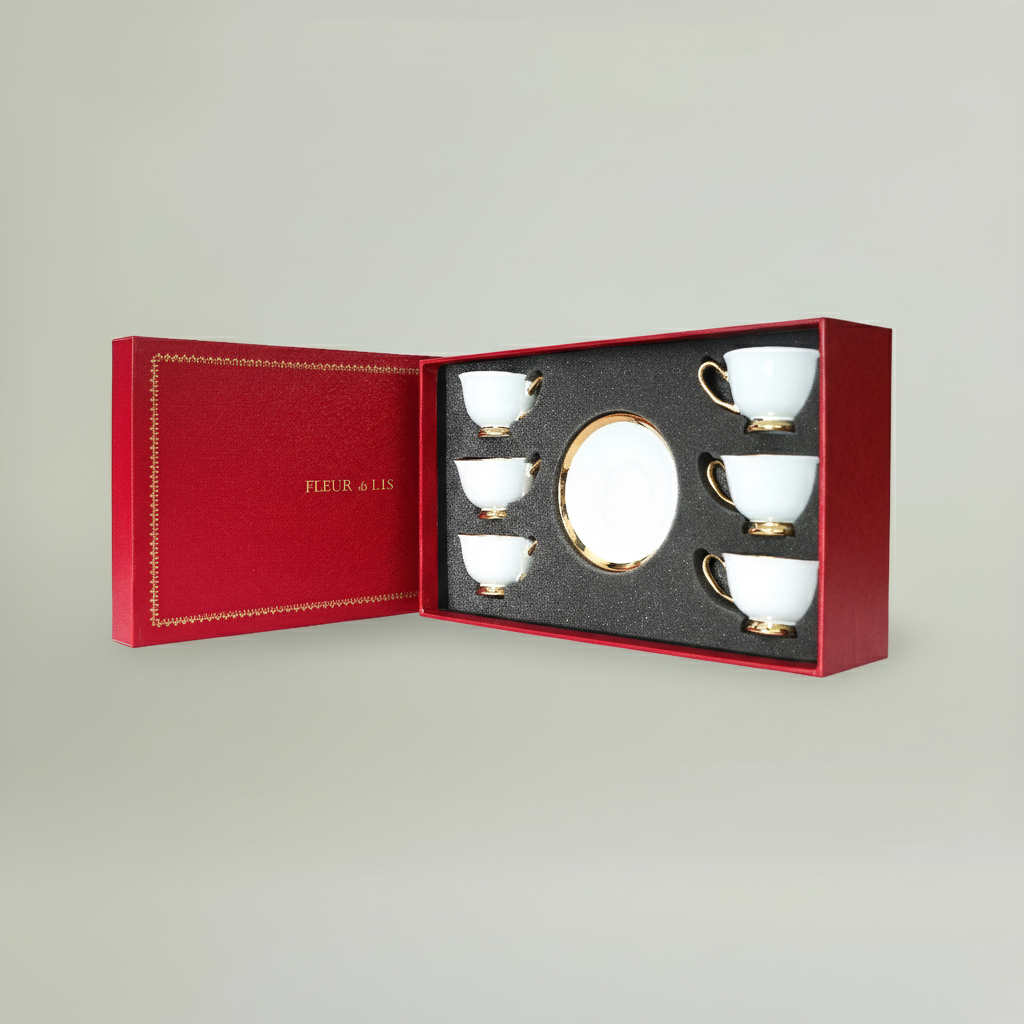 Six-piece ceramic coffee cup and saucer set with gold detailing, beautifully arranged in a premium Fleur de Lis gift box.