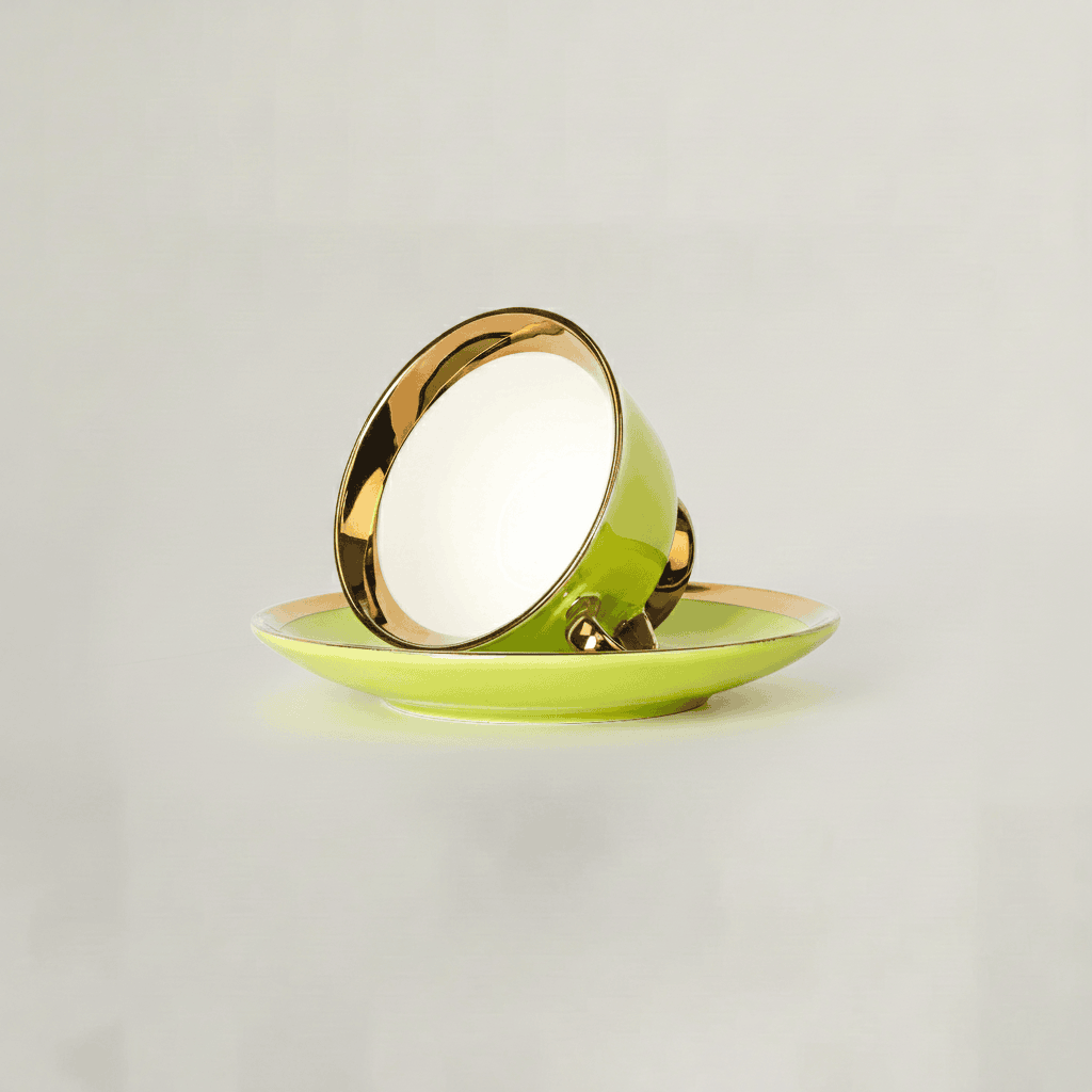 Green tea cup resting on saucer showcasing gold rim finish
