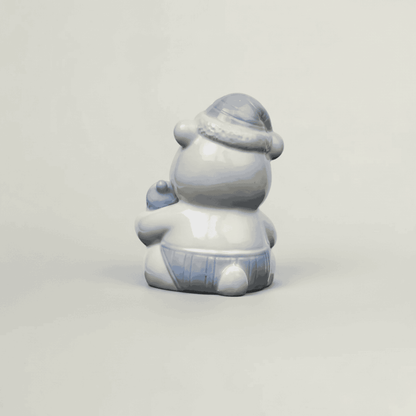 Back view of blue ceramic baby teddy bear figurine with glossy finish, pastel nursery shelf decor and baby keepsake collectible