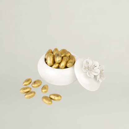 Floral ceramic jar filled with golden sugar coated almonds included in luxury baby gift hamper for newborn celebrations.