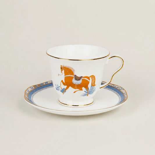 Porcelain teacup and saucer with equestrian horse motif and gold trim.