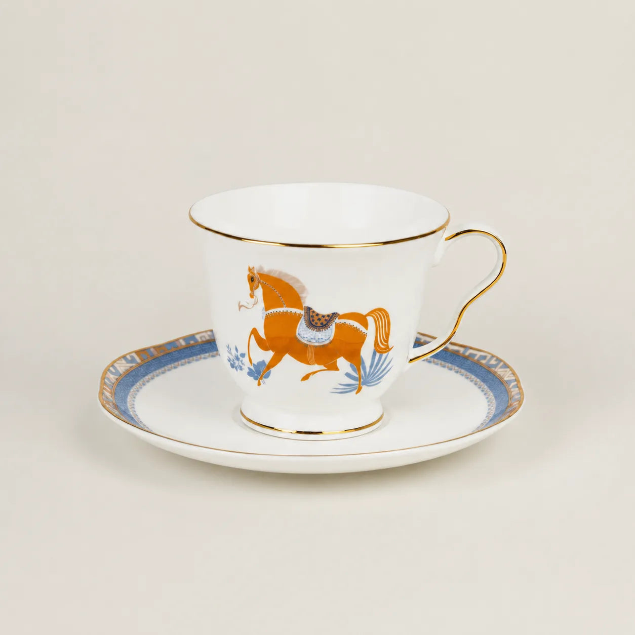 Porcelain teacup and saucer with equestrian horse motif and gold trim.