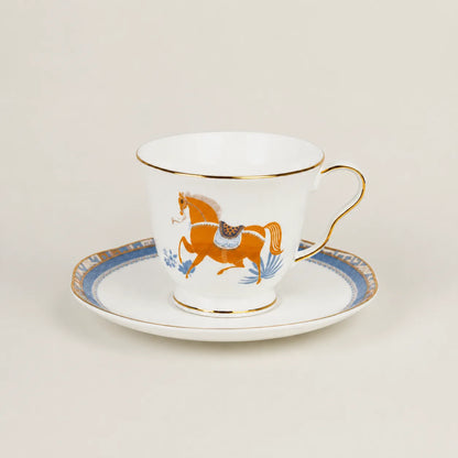 Porcelain teacup and saucer with equestrian horse motif and gold trim.