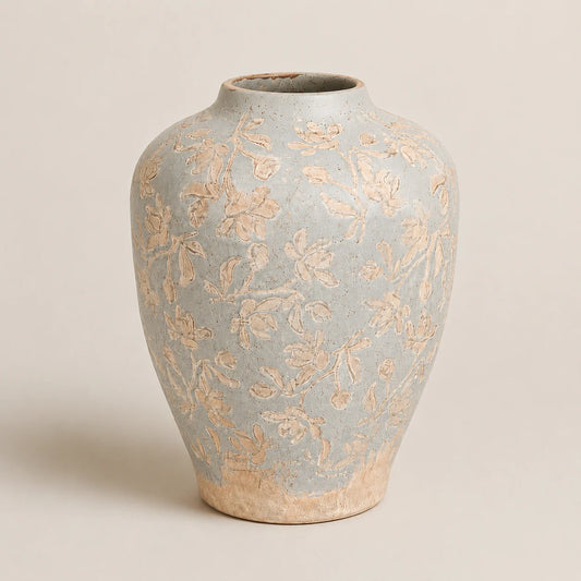 Handcrafted ceramic vase with embossed floral pattern in soft blue and beige tones.