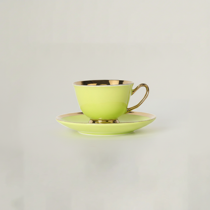 Green porcelain tea cup and saucer with gold rim by Fleur de Lis