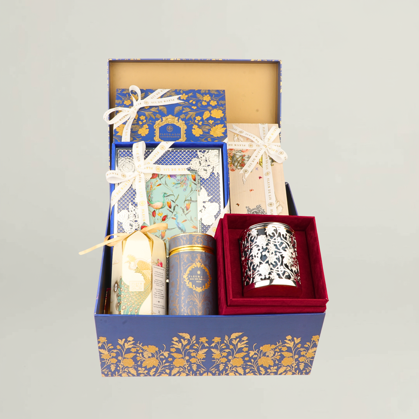Luxury Fleur de Lis gift hamper arranged in a royal blue and gold box featuring premium candle, gourmet treats, artisanal packaging, and elegant ribbon detailing.