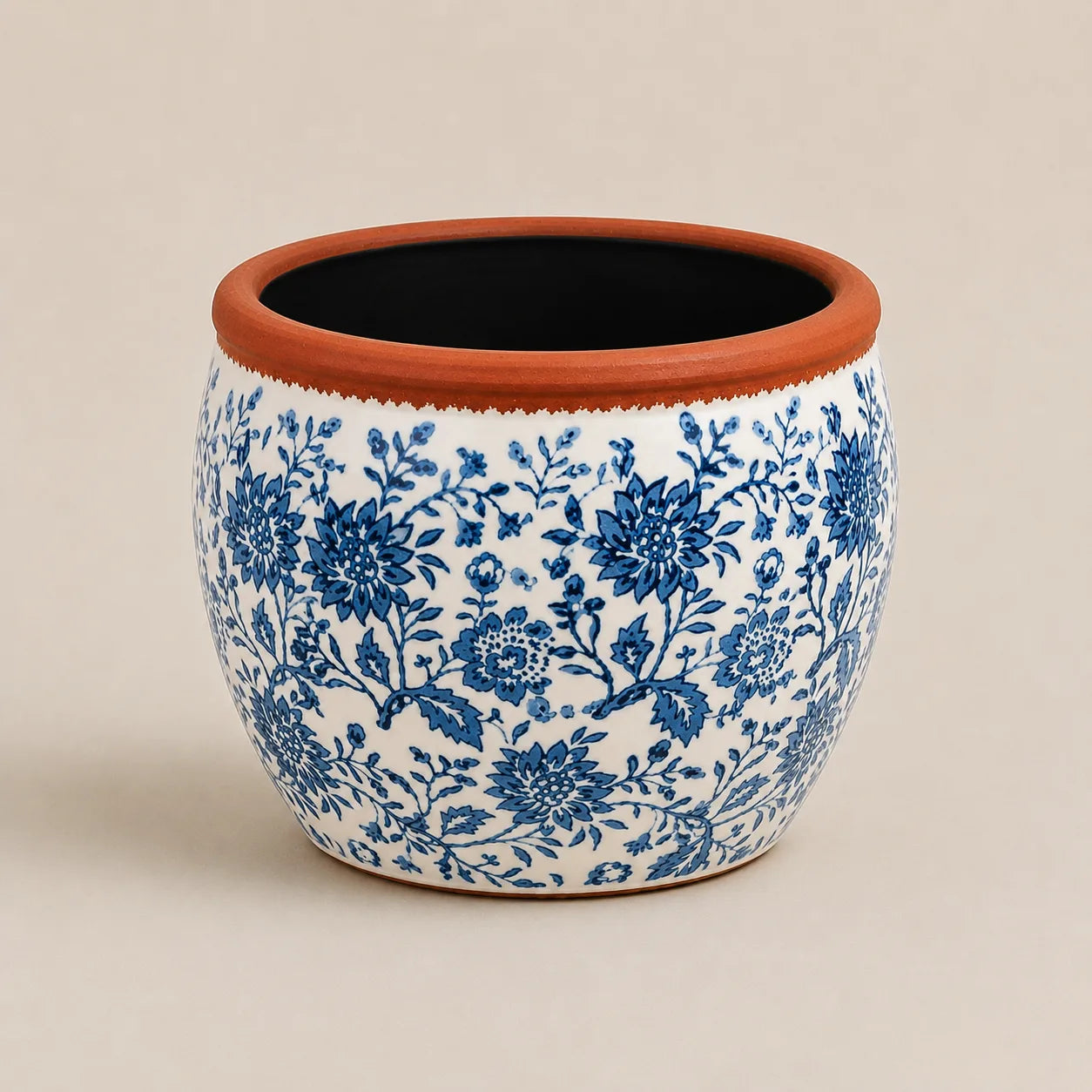 Medium ceramic planter with intricate blue floral design and rustic terracotta edge.
