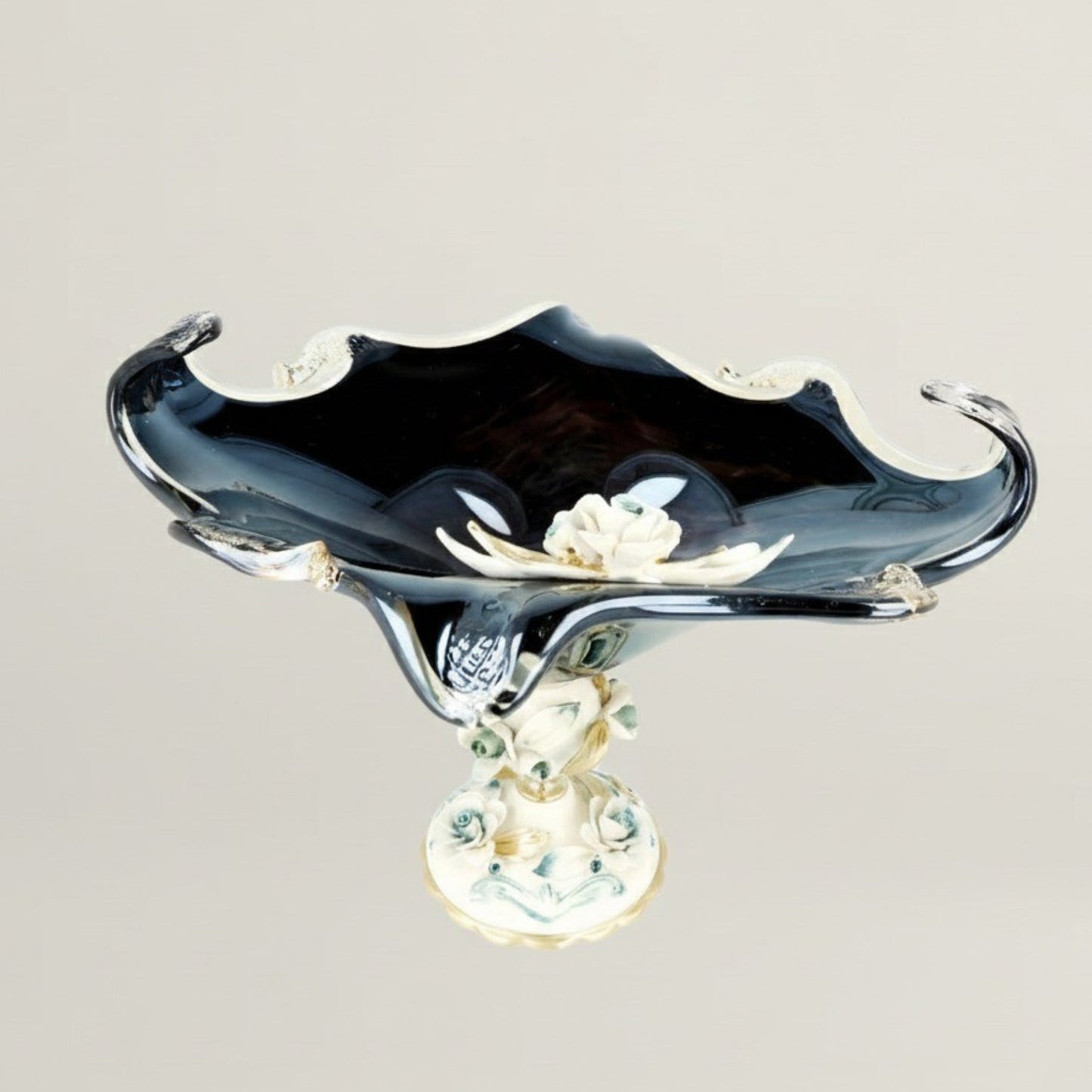 Midnight Swirl black decorative pedestal centerpiece bowl by Fleur De Lis with sculpted curved edges, deep dark finish, and floral-accented base.
