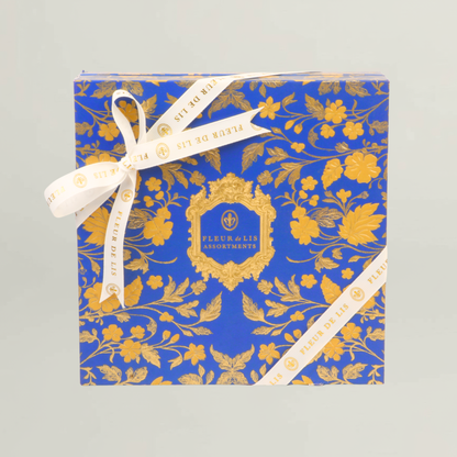 Royal blue and gold Fleur de Lis luxury hamper box with floral motifs and branded ribbon, designed for premium gifting occasions.
