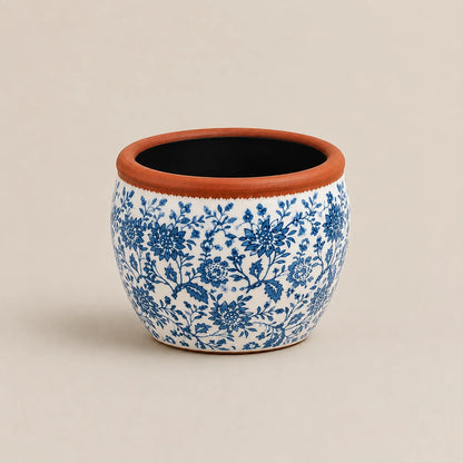 Small ceramic planter featuring hand-painted blue floral patterns and terracotta rim.