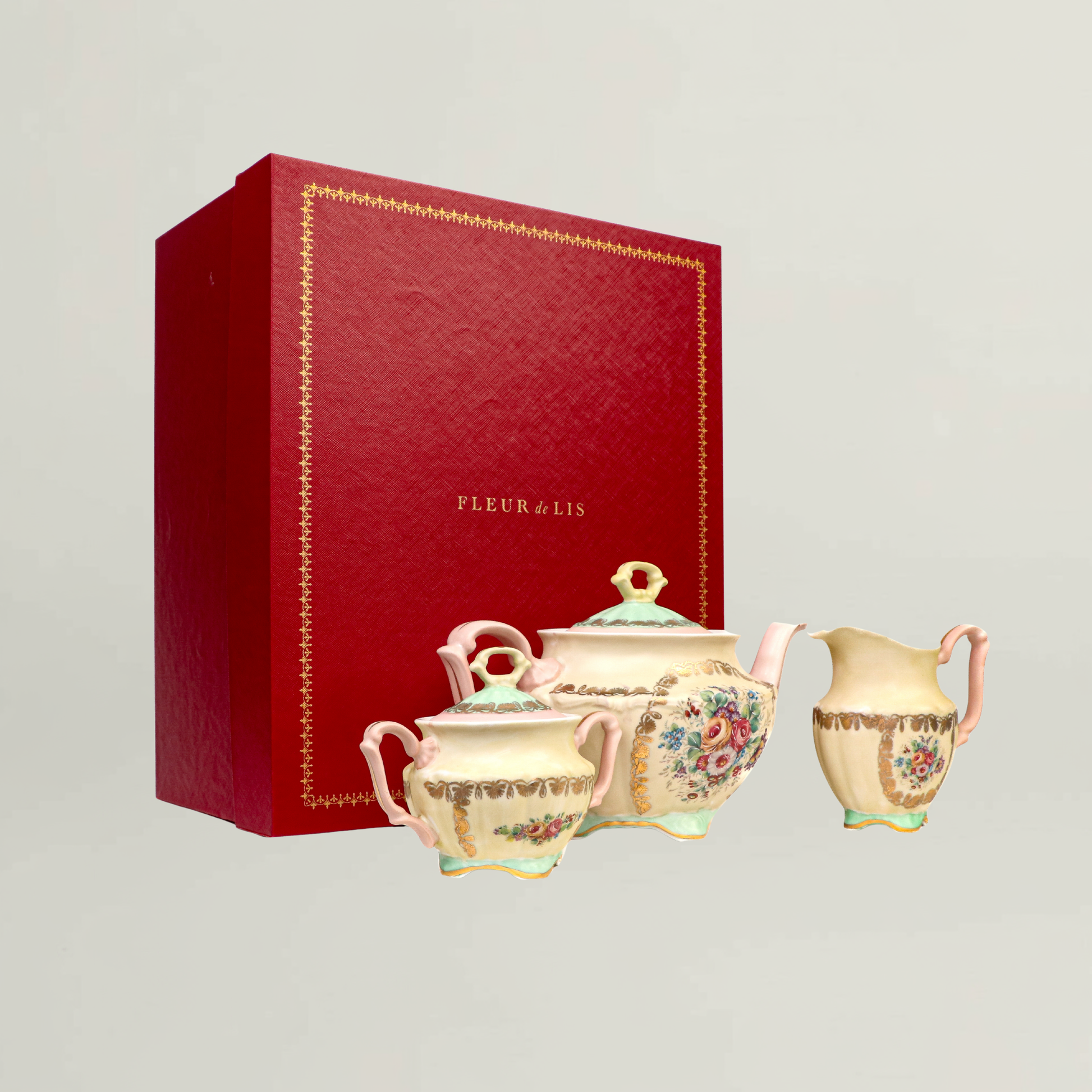 Floral ceramic teapot, sugar pot and creamer presented beside a premium Fleur de Lis gift box.