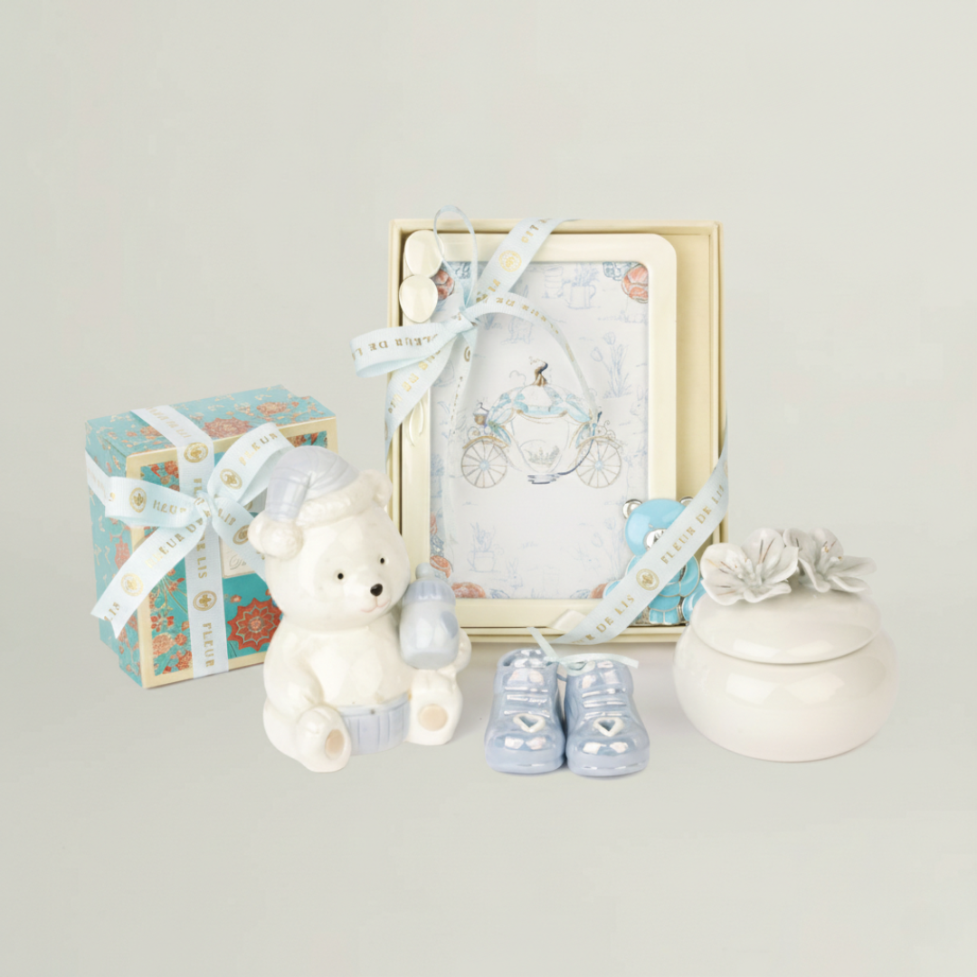 Complete kids luxury gift hamper set featuring ceramic teddy bear, baby shoes, chocolates, keepsake jar and baby photo frame in pastel blue theme.