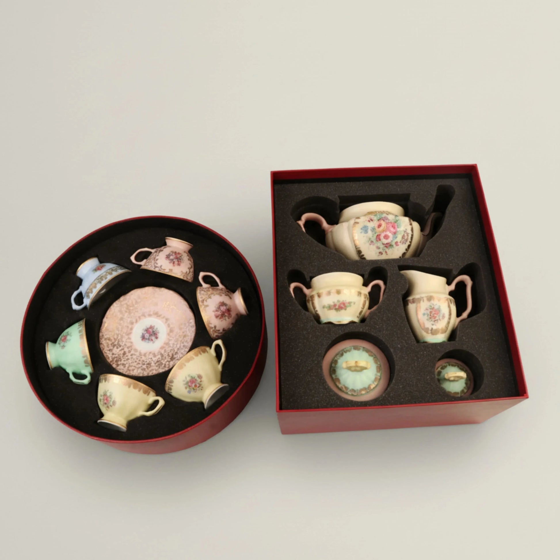 Premium ceramic tea set arranged in round and square Fleur de Lis gift boxes, showcasing intricate floral craftsmanship.