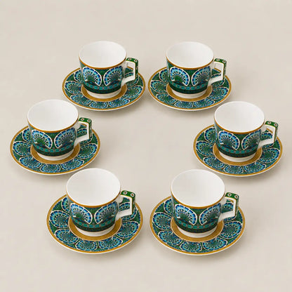 Luxury porcelain tea cup and saucer set with peacock-inspired blue and green motifs.