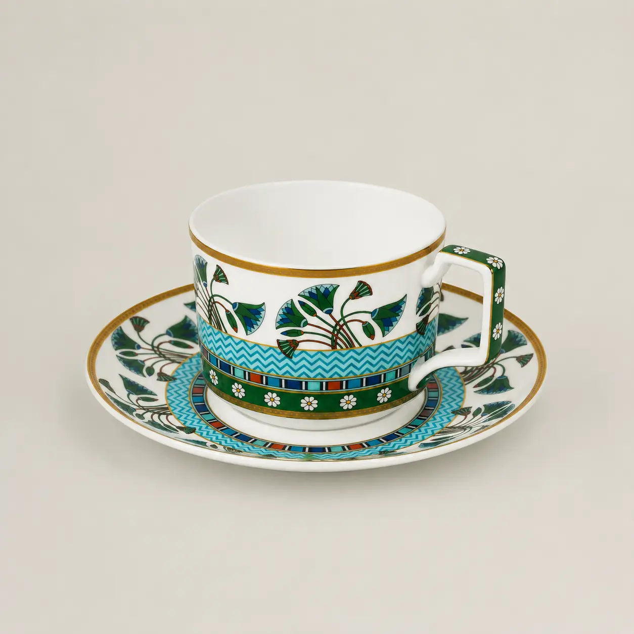 Luxury porcelain tea cup and saucer with turquoise floral patterns and gold accents.