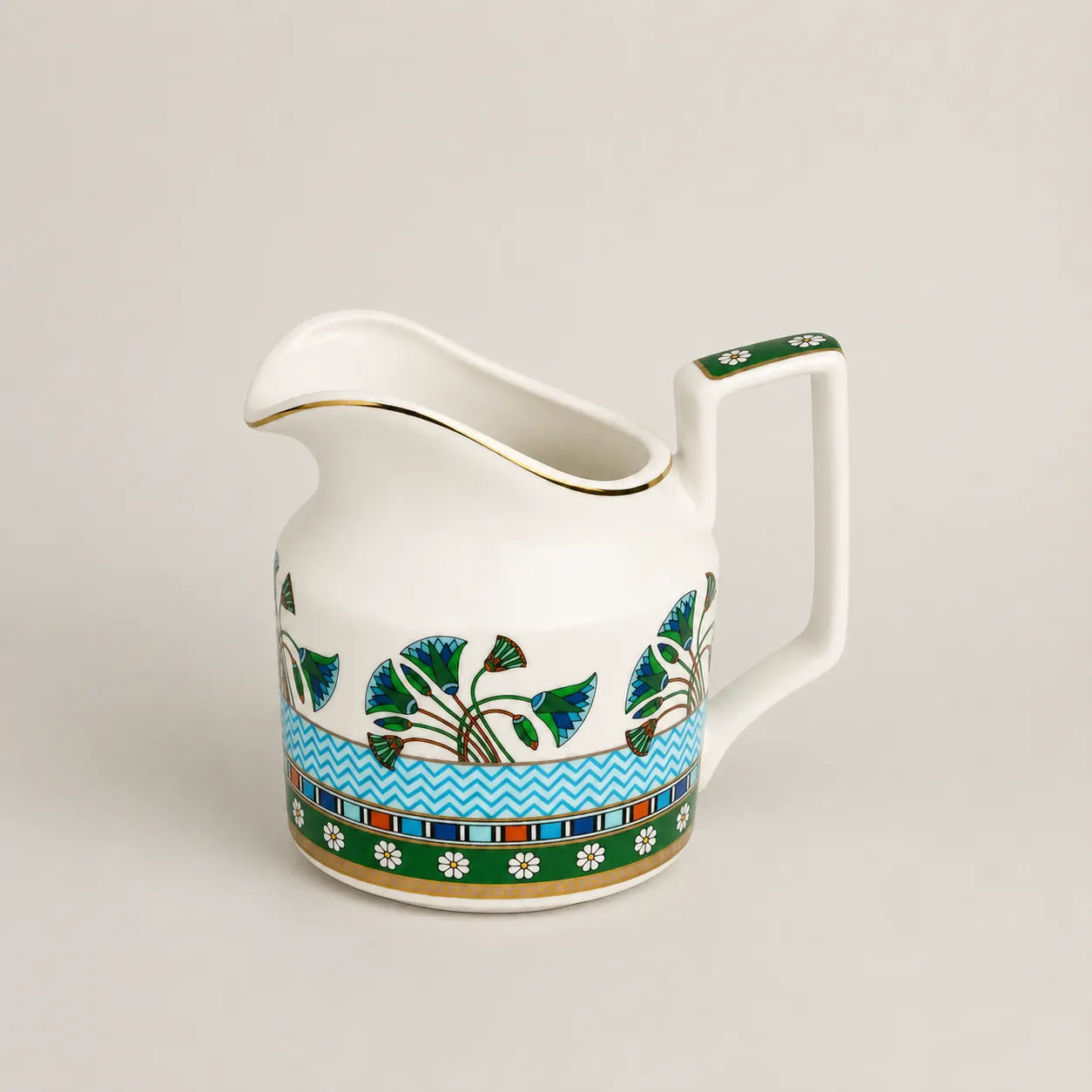 Elegant porcelain milk jug with floral motifs, gold rim and geometric handle.
