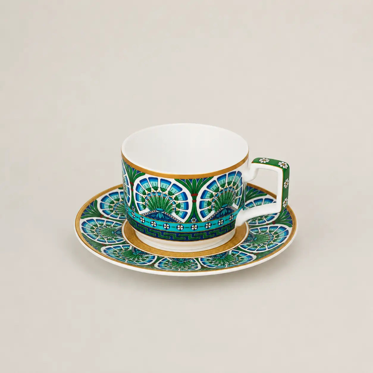Luxury porcelain tea cup with matching saucer featuring blue, green and gold detailing.