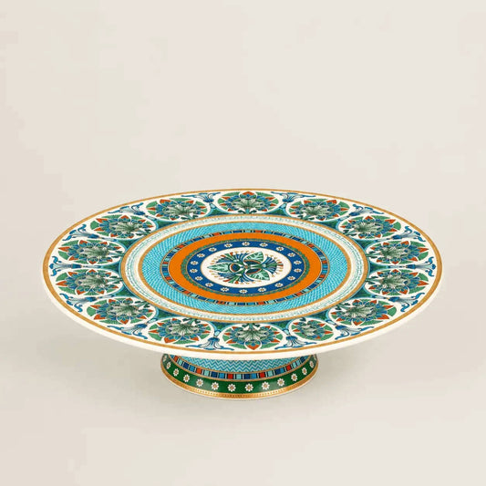 Luxury Mediterranean porcelain pedestal cake stand with intricate floral motifs and gold accents.