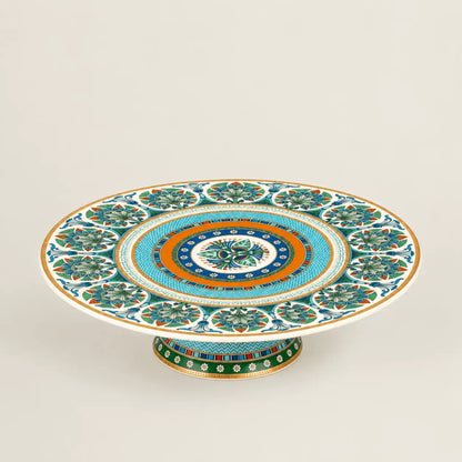 Luxury Mediterranean porcelain pedestal cake stand with intricate floral motifs and gold accents.