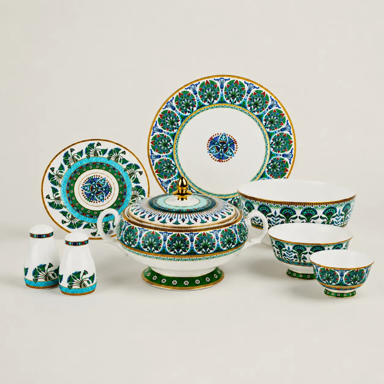 A complete luxury porcelain dinnerware collection including plates, bowls, shakers, and a tureen on a clean background.