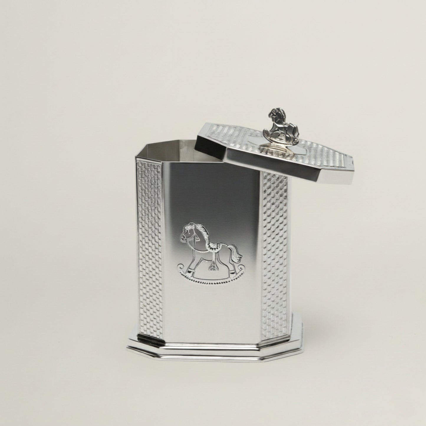 Handcrafted octagonal silver baby keepsake box featuring an engraved rocking horse motif and a miniature horse handle on the lid.