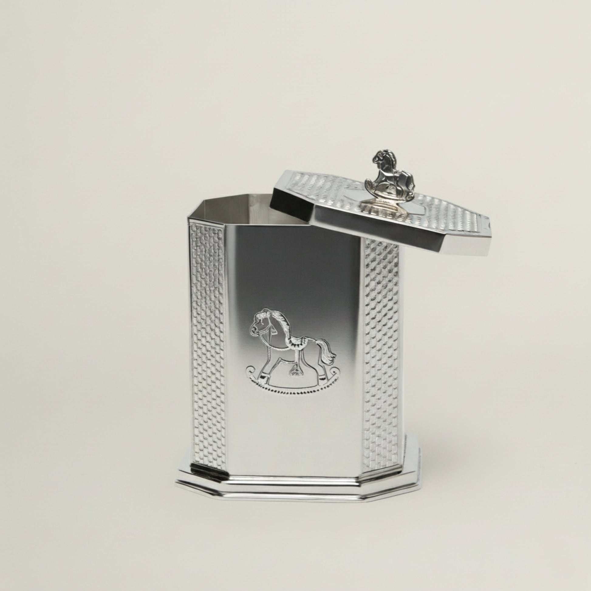 Handcrafted octagonal silver baby keepsake box featuring an engraved rocking horse motif and a miniature horse handle on the lid.